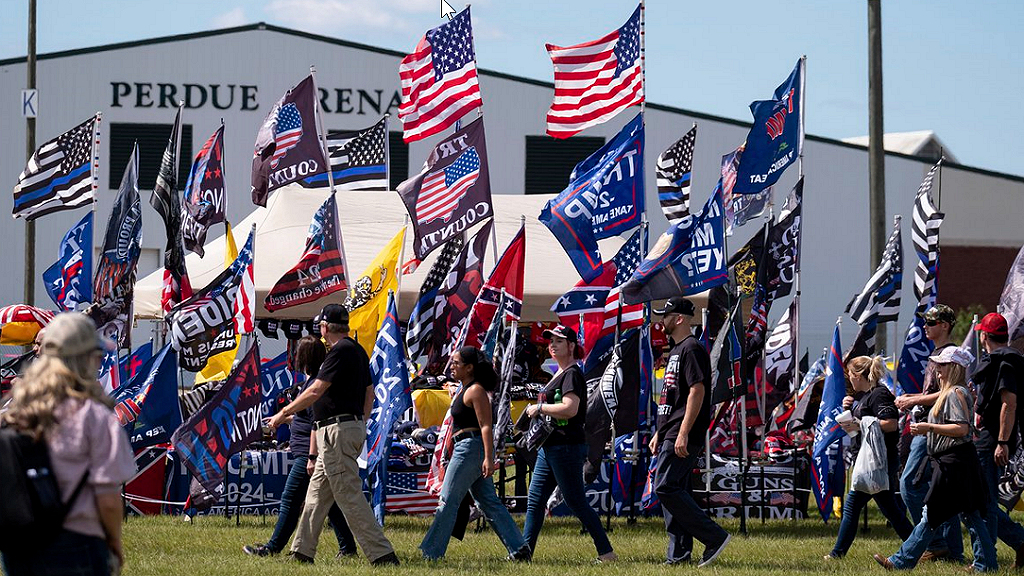 Trump Rally Perry GA supporters carry large flags.